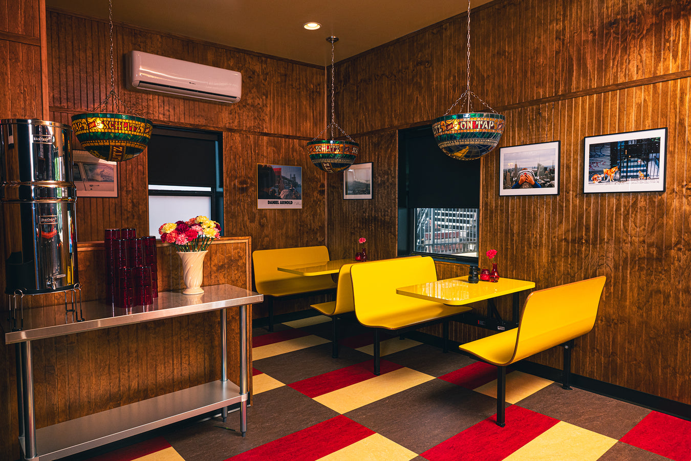 Dining room with yellow booths, wood panelling and stained glass lamps